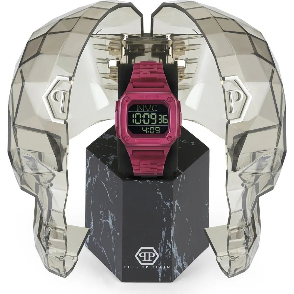 Pink digital watch on a black stand with 'Philippe Plein' branding, surrounded by geometric crystal-like structure.